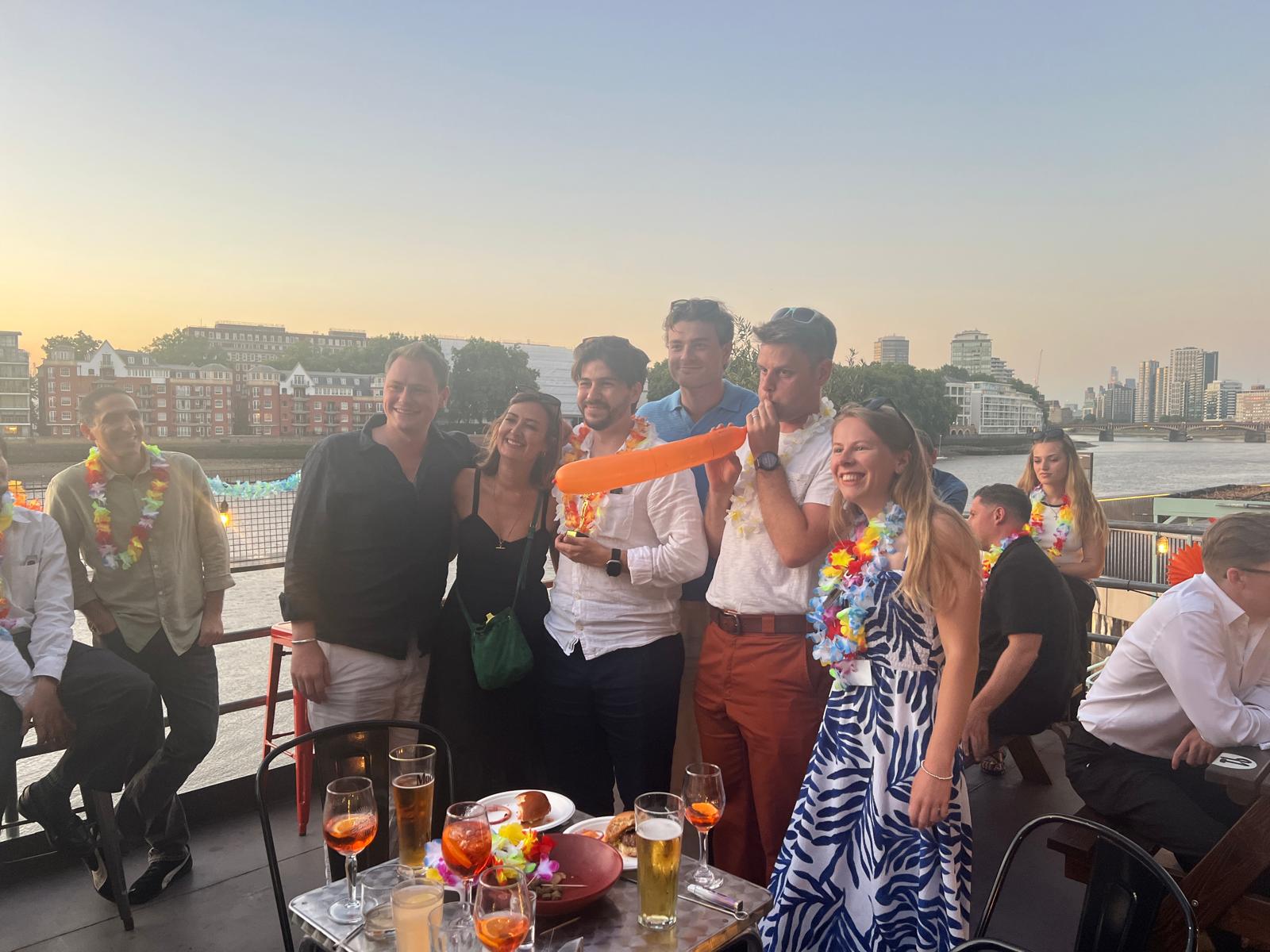 Titanbay team quiz on a riverside terrace
